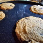 a photograph of large, thick, chocolate chip cookies.