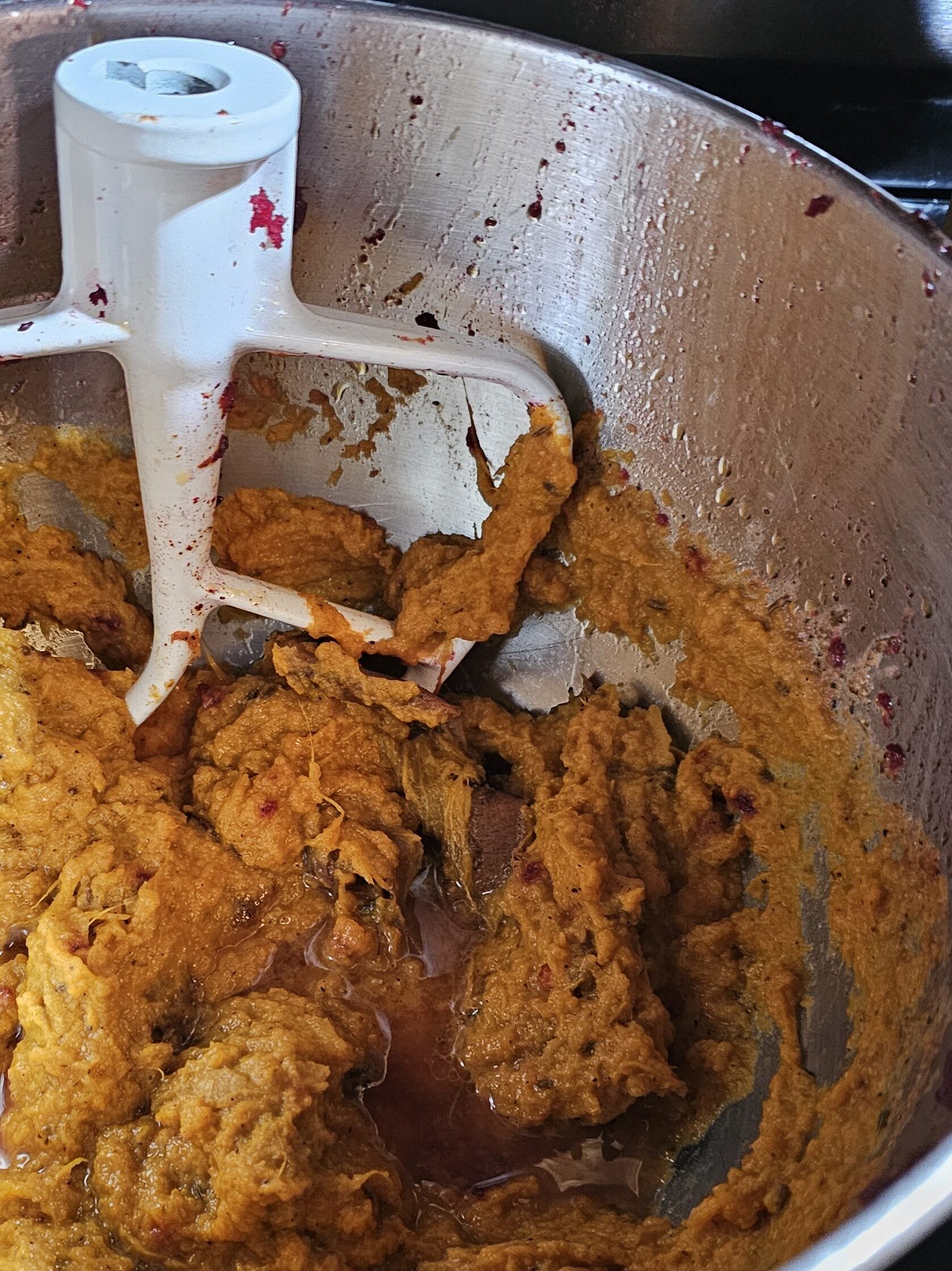 The sweet potato in the bowl of the stand mixer. A little oil is still on the surface to be mixed in.